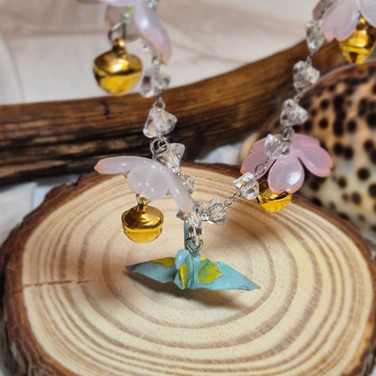 Collier grue en origami avec fleurs de sakura et grelots